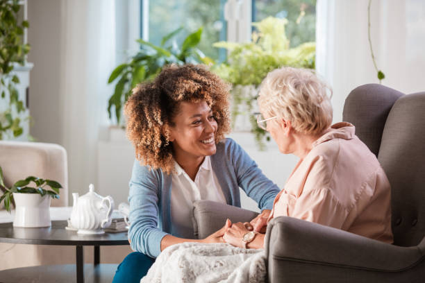 Female home caregiver talking with senior woman